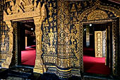 Wat Xieng Thong temple in Luang Prabang, Laos. The facade of the sim decorated with gold stencilling on a black lacquer background. 